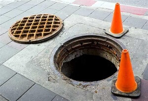 Manhole and Two Orange Cones